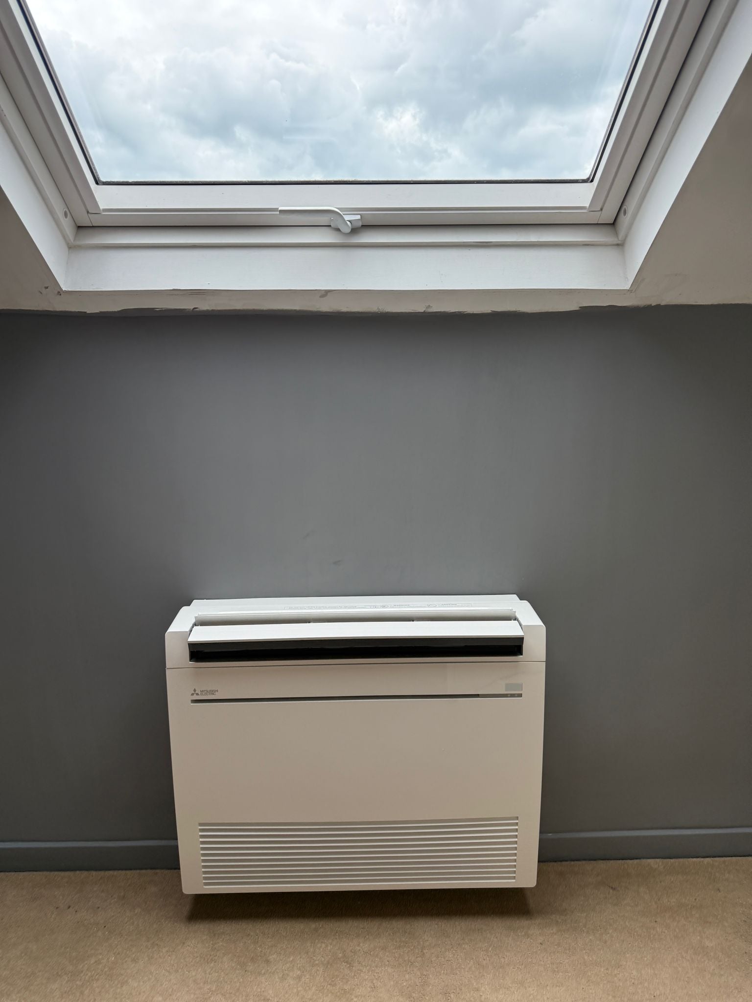 Floor mounted heat pump unit under a skylight in a Brighton townhouse