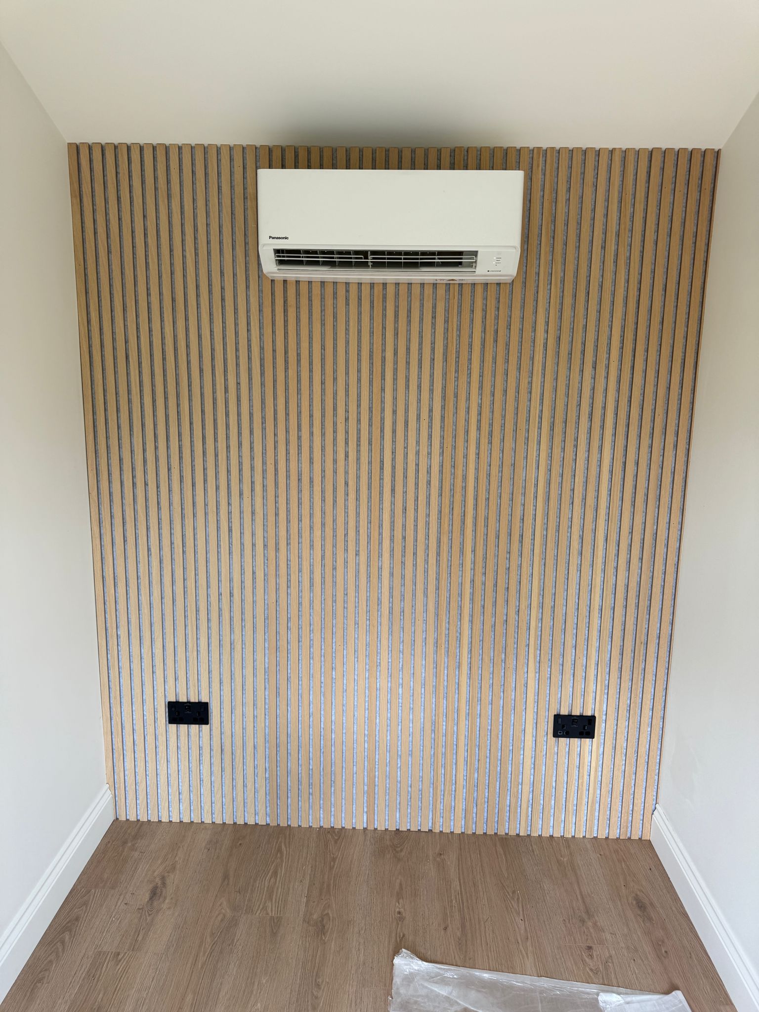 Indoor heat pump unit on a slatted feature wall in a garden office
