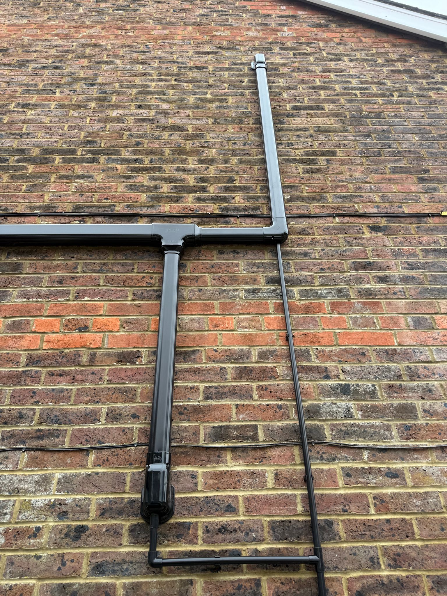 Neat black conduit routing on an exterior brick wall